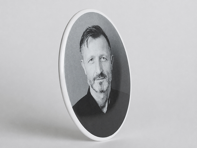 Porselein gedenkplaatje met een foto in het zwart / wit voorzien van een witte rand.